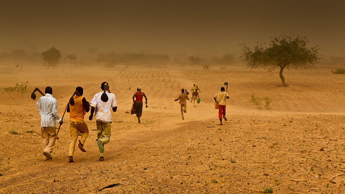 Im Niger laufen Menschen durch einen Sandsturm.