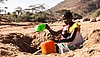Frau mit Baby an vertrockneter Wasserstelle in Kenia