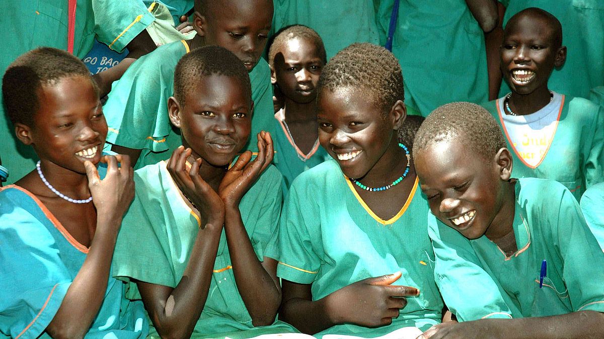 Gruppe lachender Mädchen mit grüner Kleidung im Südsudan
