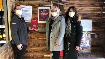 Drei Frauen stehen neben einer Spendenbox