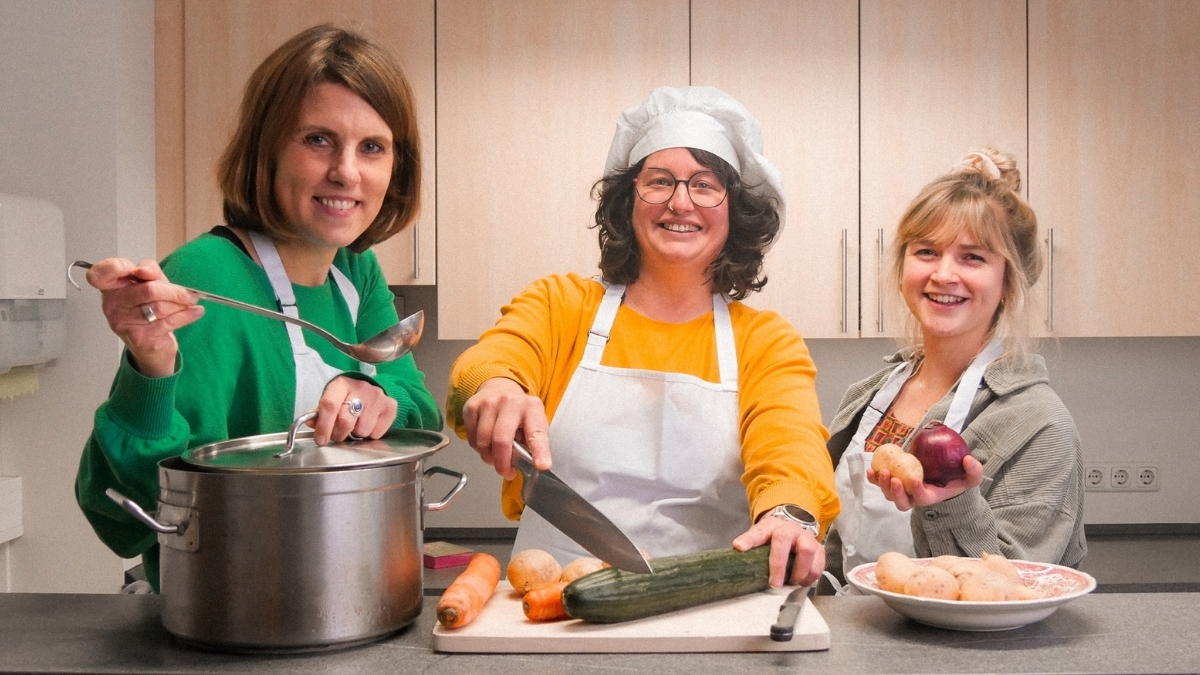 Drei Misereor-Mitarbeiterinnen mit Kochutensilien in einer Küche