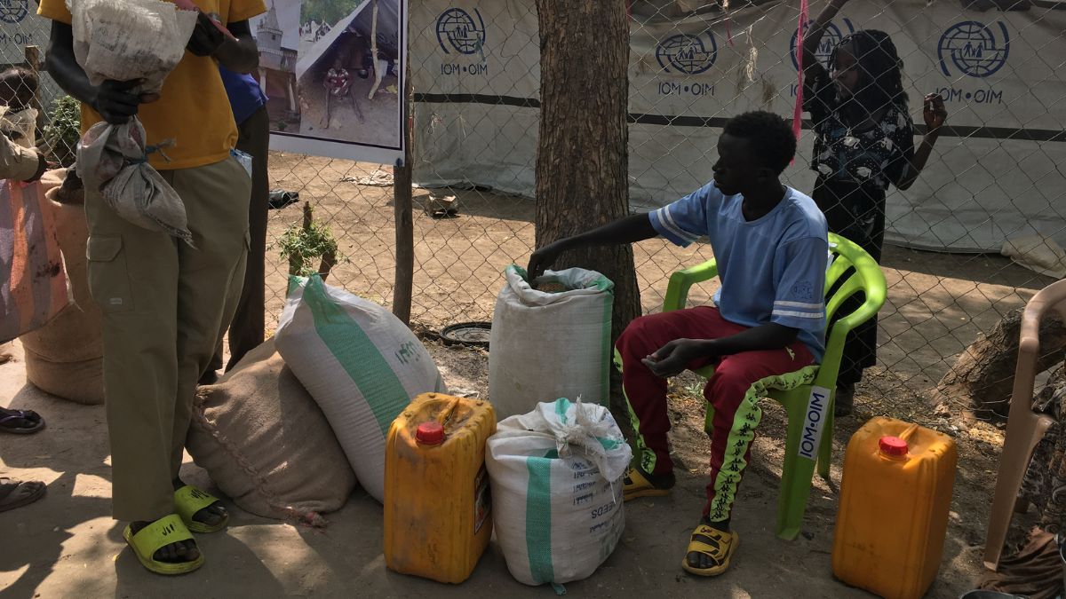 Menschen bei einer Lebensmittelausgabe auf staubigem Boden im Südsudan
