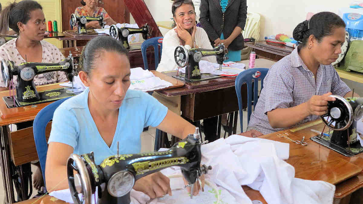 Frauen lernen in ihrer Ausbildung den Umgang mit Nähmaschinen