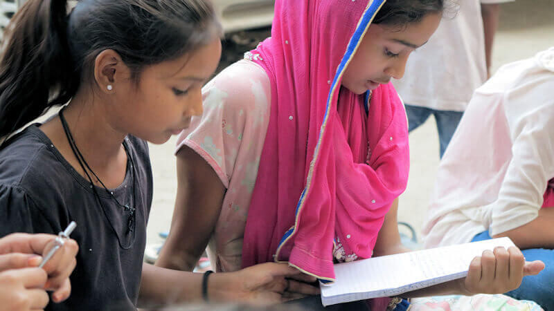 Zwei Mädchen schauen konzentriert auf ihre Schulbücher